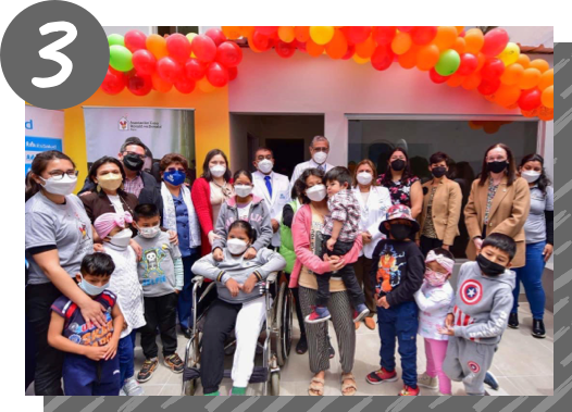 A group of families and medical staff stand under a balloon arch in the RMHC Peru Ronald McDonald Local Program space.